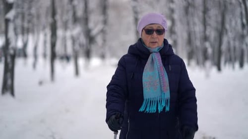 Senior Woman Nordic Walking in Snowy Winter Park