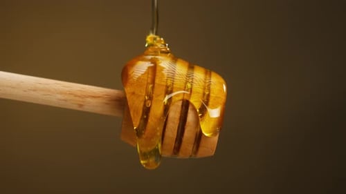 Süßer Honig fließt auf Holzlöffelspindel Nahaufnahme