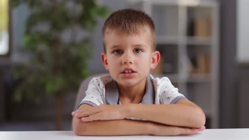 Smiling Child Sitting at Table