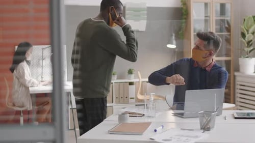 Masked Office Workers Safely Bumping Elbows at Work