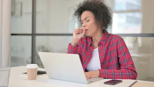 Woman Coughing While Working on Laptop in Office
