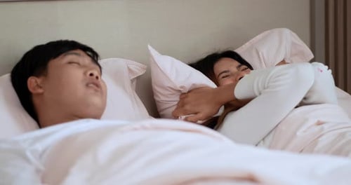 Asiatique jeune femme agacée par le ronflement de son mari