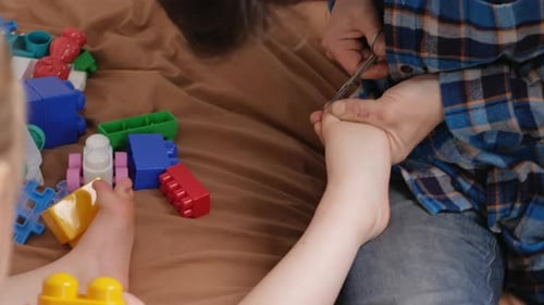 Adult Clipping Child's Toenails at Home