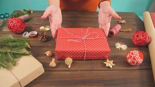 Hands Tying String Around Christmas Gift Box
