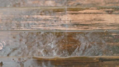 Wassertropfen schlagen gegen eine Holzoberfläche