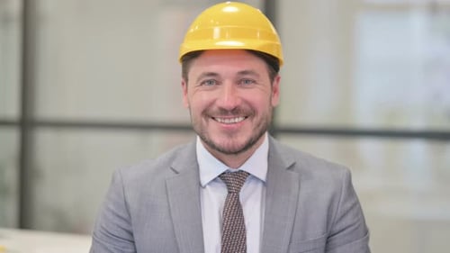 Porträt eines attraktiven Ingenieurs mittleren Alters, der in die Kamera lächelt