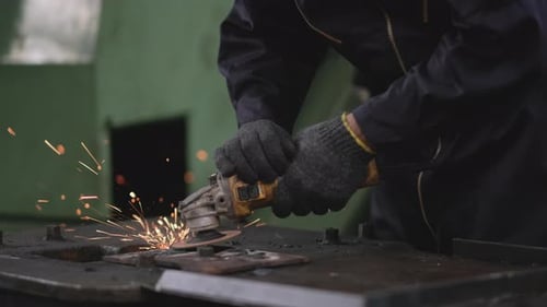 Close up side view hands of factory workers work with metal grinding and show bright splash