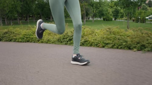 Woman running in the park, legs close-up