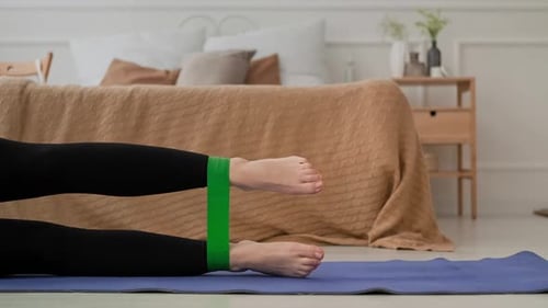 Woman Exercising Legs with Resistance Band at Home