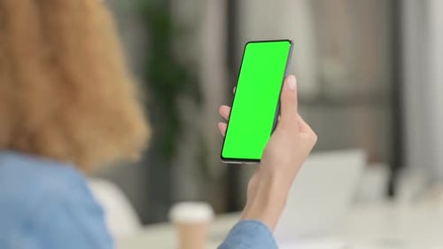 Rear View of African Woman Using Smartphone with Green Chroma Key Screen
