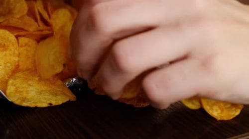 Grabbing Tasty Potato Chips from Pile