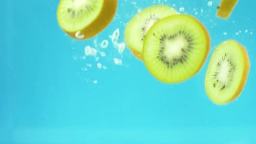 Fresh Kiwi Slices Falling into Water