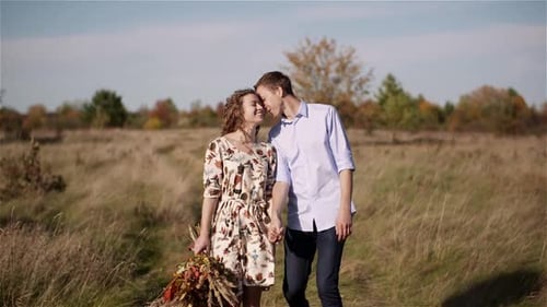 Young Couple Walking on a Meadow