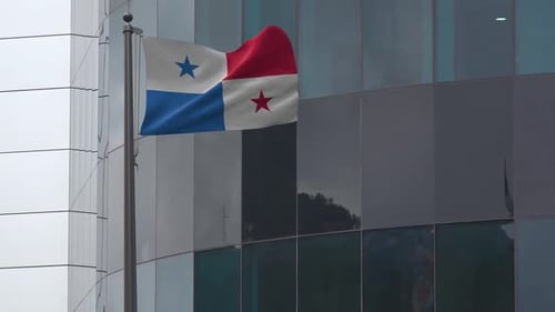 Panama Flag Waving in Wind Against Modern Office Building