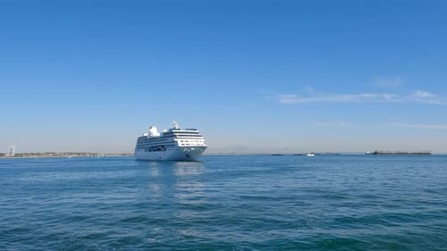 Riding through the harbor on a boat and passing a cruise ship in the bay