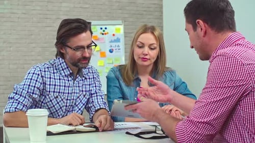 Professionals Collaborating on Tablet in Modern Office