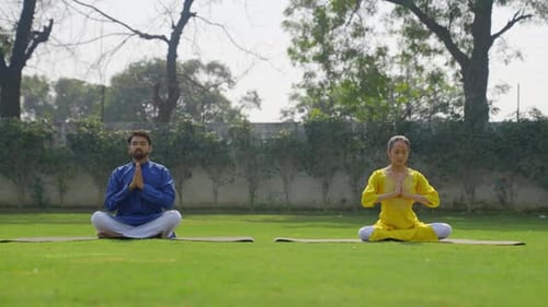 Man and Woman Meditating Outdoors in Yoga Pose