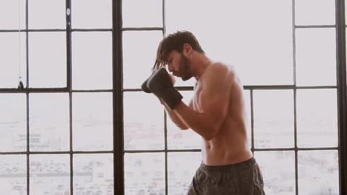 Muscular Man Shadow Boxing in Urban Loft