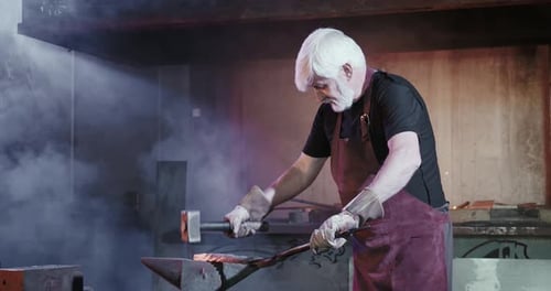 Blacksmith Forging Metal on Anvil in Workshop
