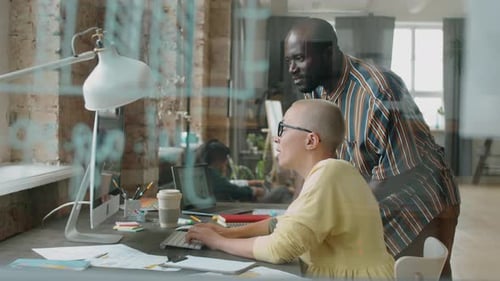 Multiethnische Mitarbeiter diskutieren Projekt am Computer im Büro