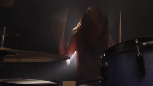 Man playing drums in heavy metal rock band, slow motion