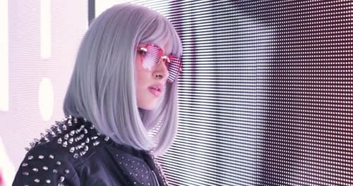 Filmmusik Bild einer schönen jungen Frau, die vor einem LED-Panel posiert