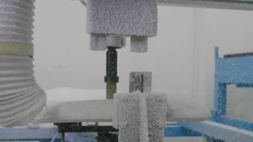 Surfboard being shaped by a machine in a workshop