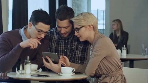 Creative Team Using Smartphone and Talking in Casual Office