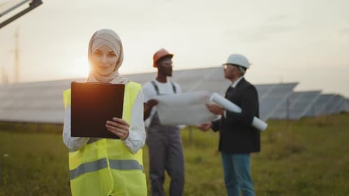 Engineers Planning Sustainable Solar Farm at Sunset