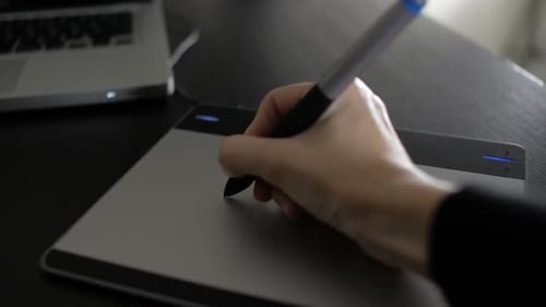 Hand Using Stylus on a Graphics Tablet