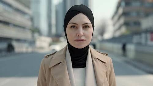 Portrat of Attractive Arabian Business Woman in Hijab Standing on Street of Big City Looking Into