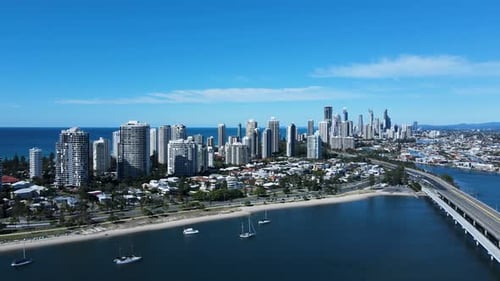 Luftaufnahme einer Zersiedelung einer städtischen Metropole an der Küste mit einer hoch aufragenden Hochhaus-Skyline und städtischen Infrastrukturen