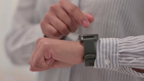 Close Up of Hands of African Woman Using Smart Watch