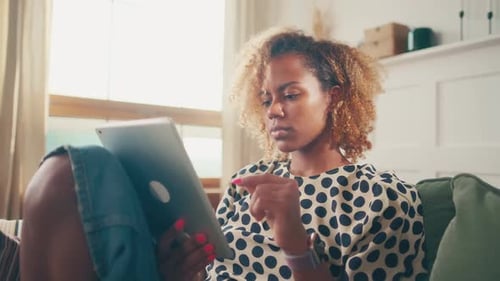 Young Woman Relaxing at Home Using Tablet