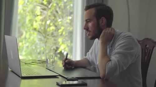 Man Drawing on Graphics Tablet at Home