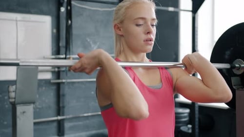 Young Woman Lifting Barbell Training in Gym Enjoying Bodybuilding Exercise