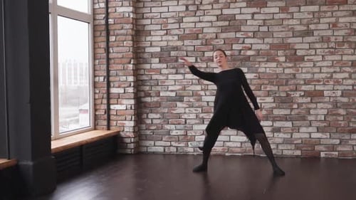 Woman Dancing Gracefully in an Urban Loft Studio