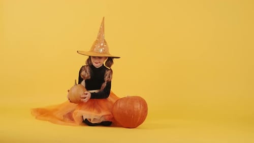 Little Blonde Girl in Witch Costume on Halloween at Orange Studio Background