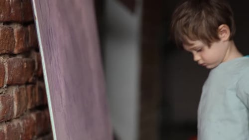 Young Child Standing by a Blank Canvas