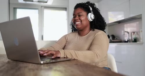 Woman working at laptop in bright home setting