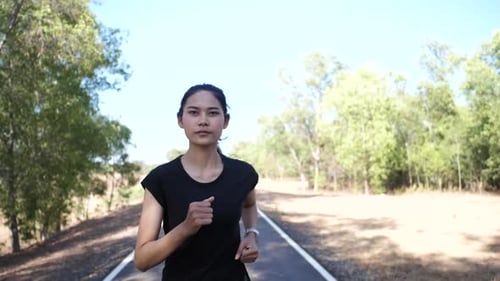 Woman Running on Road in Rural Setting