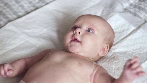 Cute Baby Lying on a White Surface