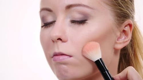 Woman Applying Makeup with a Brush Close Up