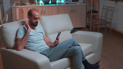 Man on Sofa Video Calling With Smartphone