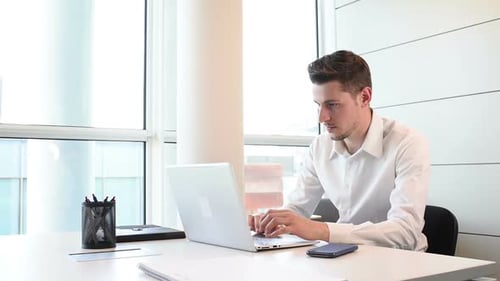 Inneneinrichtung des jungen Geschäftsmannes mit Laptop-Computer und Smartphone