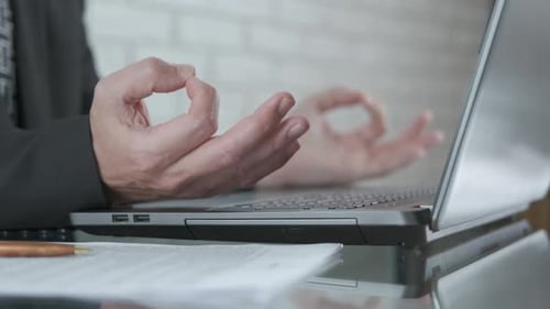 Person Typing on Laptop and Meditating