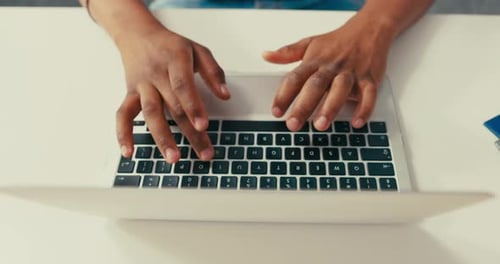 Hands Typing on a Laptop Computer at a Desk