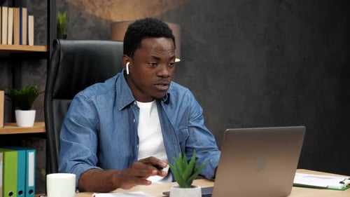 Man Working at Laptop in Modern Office Setting