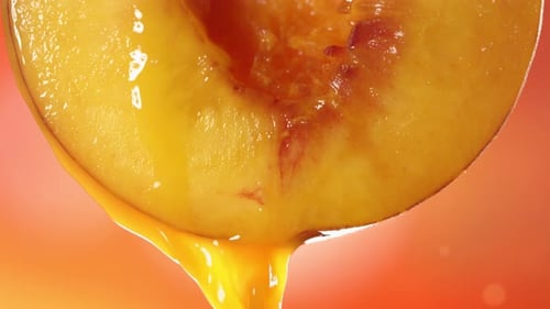 Slow Motion Macro Shot of Flowing Peach Juice From Half Peach