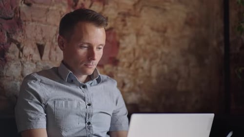 Man Working on Laptop Computer in Urban Setting